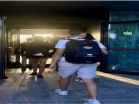 Imagen de estudiantes atravesando el umbral de entrada al centro con luz natural de fondo